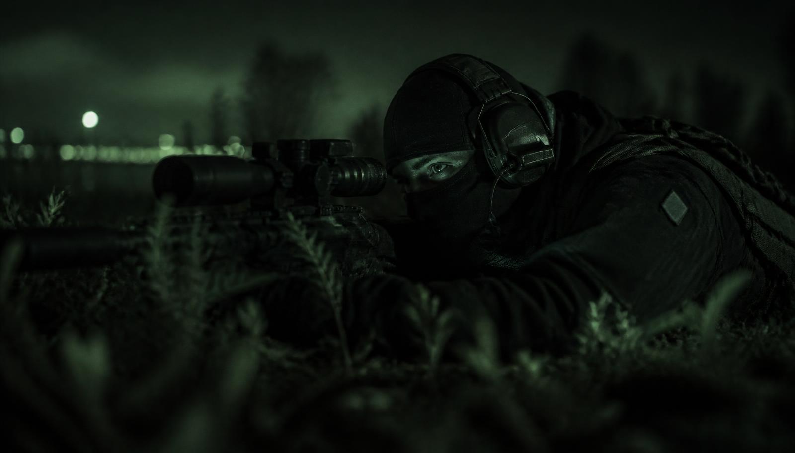 Operator in der Nacht in Beobachtungsposition als Symbol für Daueraufmerksamkeit