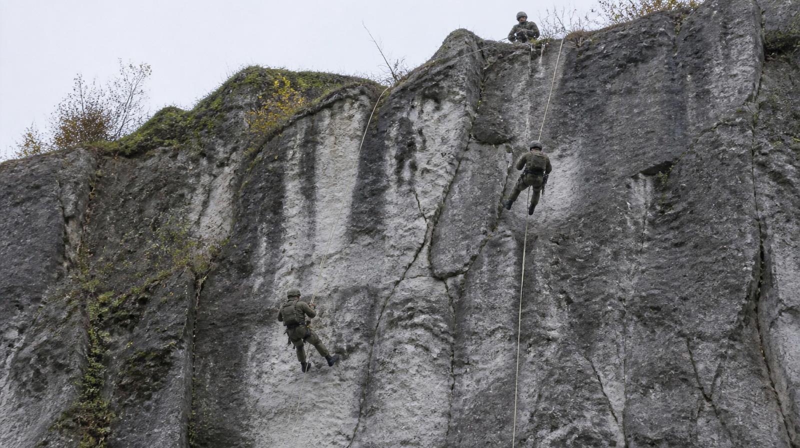 Belgische Commando-Kandidaten beim Abseilen an einer Kalksteinwand im Ausbildungszentrum Marche-les-Dames — Commando-A-Qualifikation.